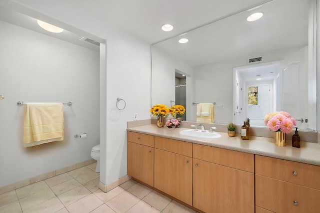 bathroom with toilet, tile patterned floors, and vanity