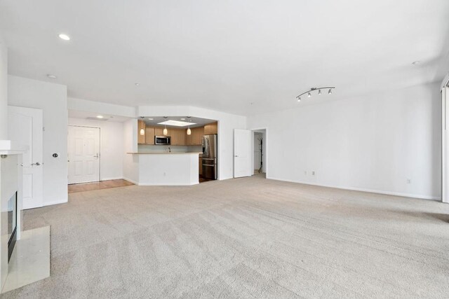 unfurnished living room featuring light carpet