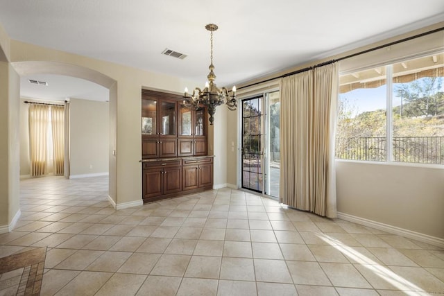 unfurnished dining area featuring a healthy amount of sunlight, a chandelier, and light tile patterned floors