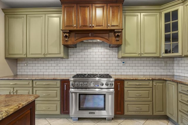 kitchen featuring light stone counters, stainless steel range, backsplash, and light tile patterned floors