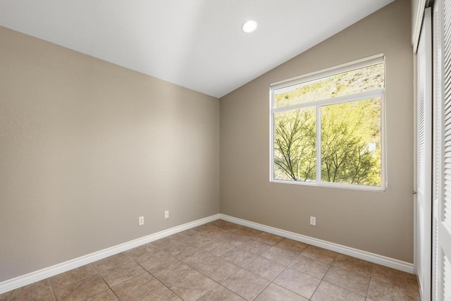 spare room with lofted ceiling and light tile patterned floors