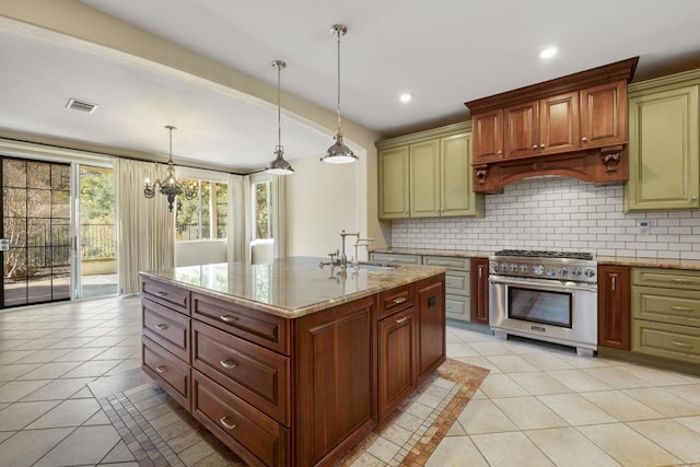 kitchen with light stone countertops, pendant lighting, decorative backsplash, high end stainless steel range, and sink