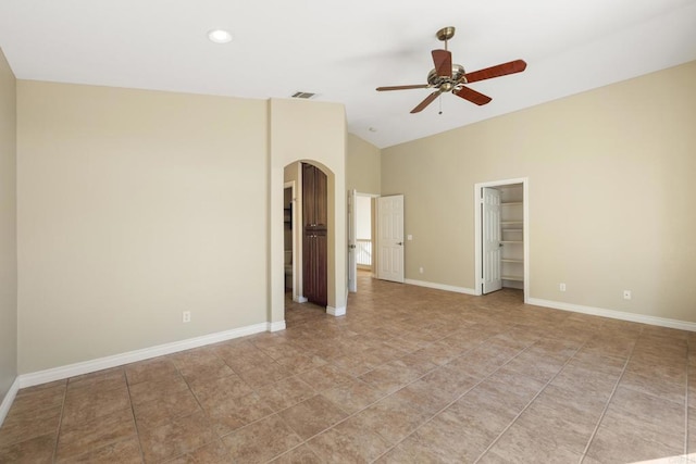 unfurnished bedroom with a closet, ceiling fan, and a spacious closet