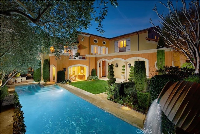 back of house featuring a balcony, a patio, and pool water feature