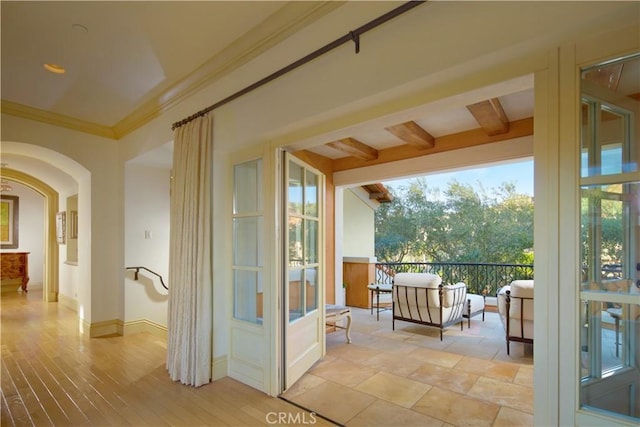 entryway with ornamental molding and beamed ceiling