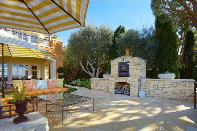 view of patio featuring an outdoor living space with a fireplace