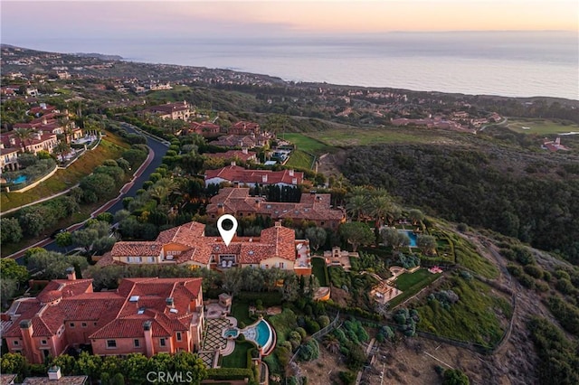 aerial view at dusk featuring a water view