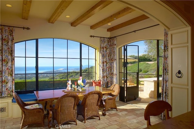 sunroom with a water view and beamed ceiling