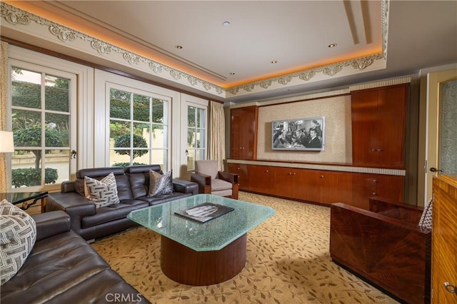 home theater room featuring light carpet and a tray ceiling