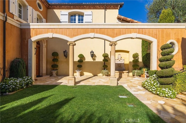 rear view of property with a yard and a patio