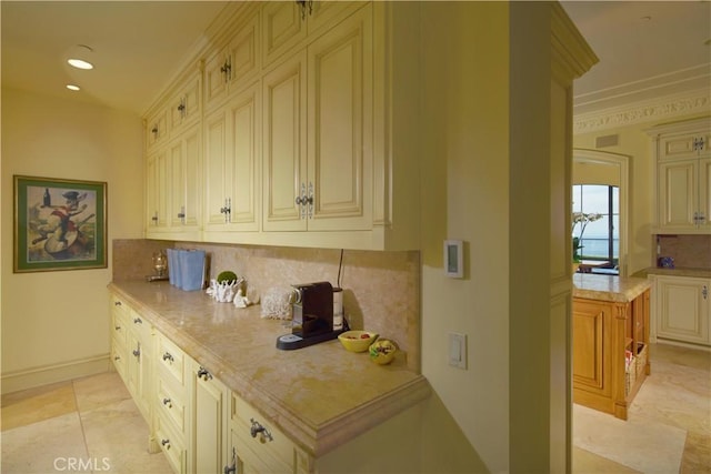 kitchen with cream cabinets, crown molding, decorative backsplash, and light tile patterned floors