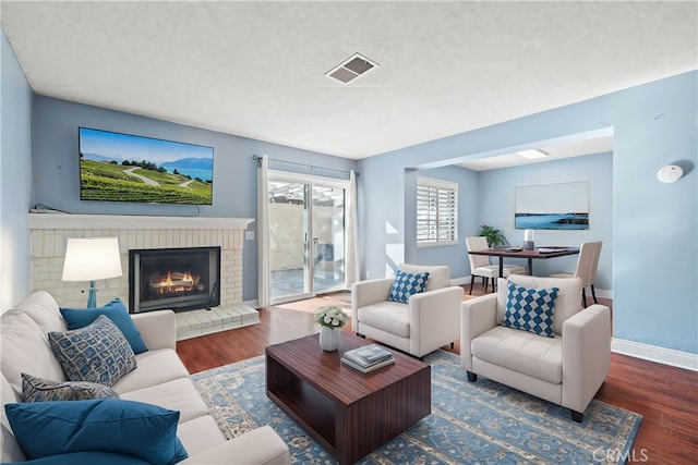 living room with dark hardwood / wood-style floors and a fireplace