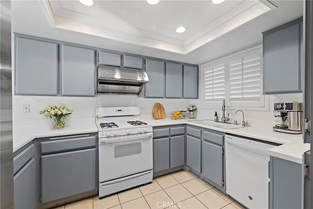 kitchen featuring white appliances, gray cabinetry, sink, and a tray ceiling