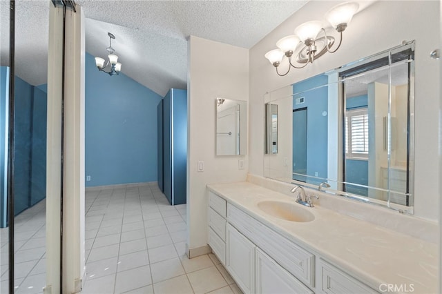 bathroom with a textured ceiling, lofted ceiling, tile patterned flooring, vanity, and a notable chandelier