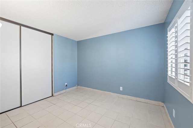 unfurnished bedroom with a textured ceiling and a closet