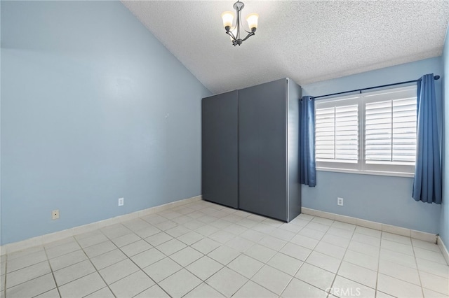 unfurnished bedroom with a notable chandelier, vaulted ceiling, and a textured ceiling