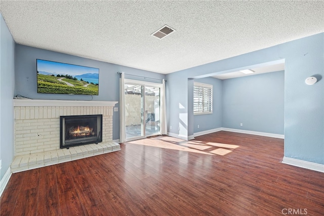 unfurnished living room with a textured ceiling, hardwood / wood-style floors, and a fireplace