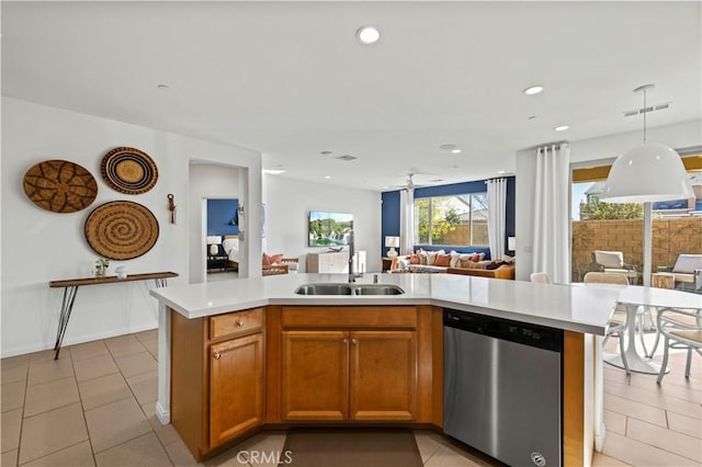 kitchen with a center island with sink, hanging light fixtures, light tile patterned floors, sink, and stainless steel dishwasher