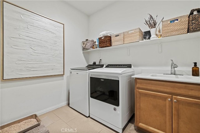 clothes washing area with sink, cabinets, independent washer and dryer, and light tile patterned floors