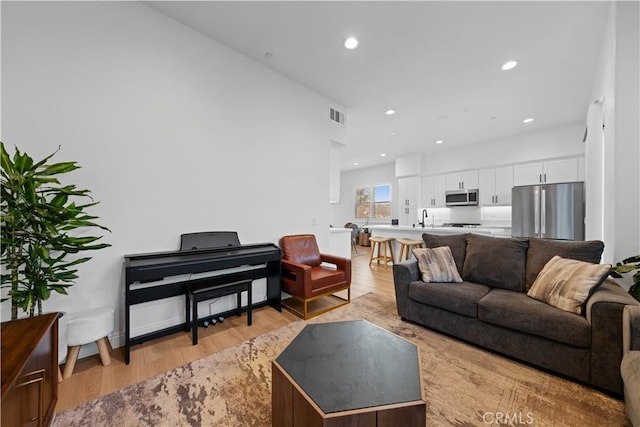 living room with sink and light wood-type flooring