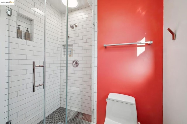 bathroom with toilet and a shower with shower door