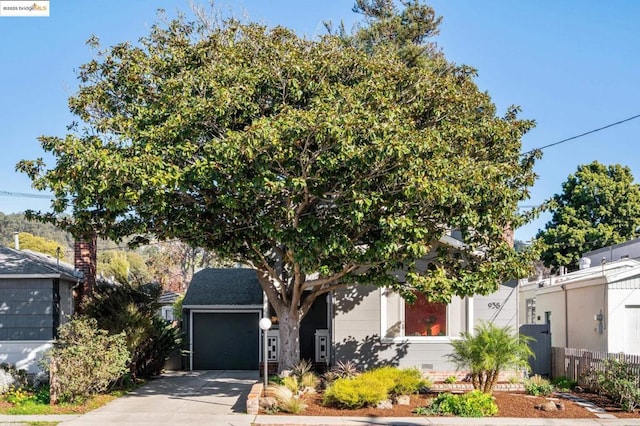 view of property hidden behind natural elements featuring a garage