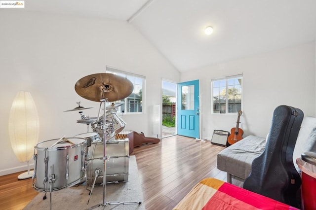 sitting room with light wood-type flooring and high vaulted ceiling