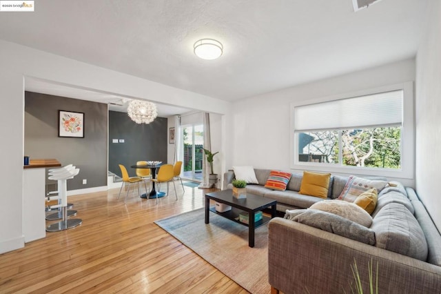 living room featuring light hardwood / wood-style floors and an inviting chandelier