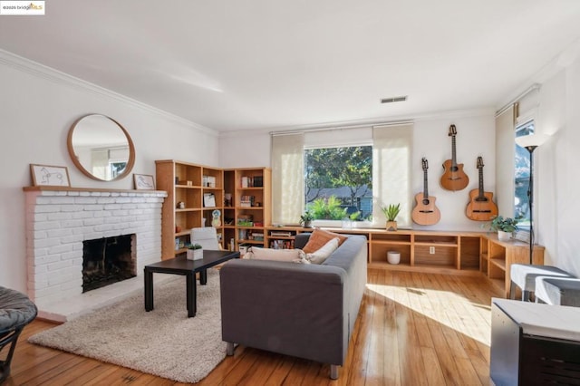 living room featuring a brick fireplace, plenty of natural light, and crown molding