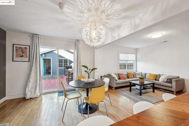 dining space with a chandelier and light hardwood / wood-style floors