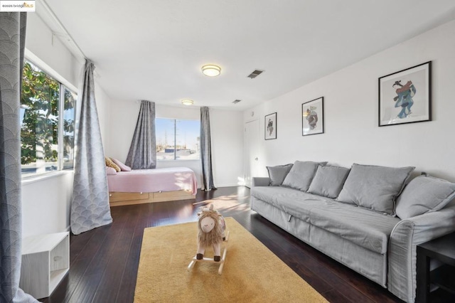 bedroom with dark hardwood / wood-style floors and multiple windows