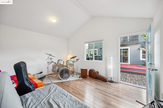 bedroom featuring multiple windows, light hardwood / wood-style flooring, and lofted ceiling with beams