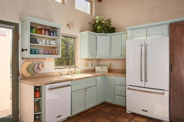 kitchen featuring a high ceiling, sink, and white appliances