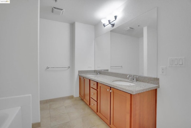 bathroom with vanity, tile patterned flooring, and a tub