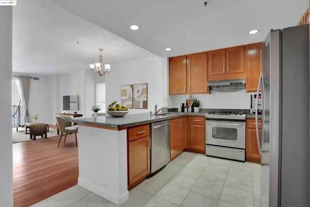 kitchen featuring stainless steel appliances, sink, light tile patterned flooring, kitchen peninsula, and a chandelier