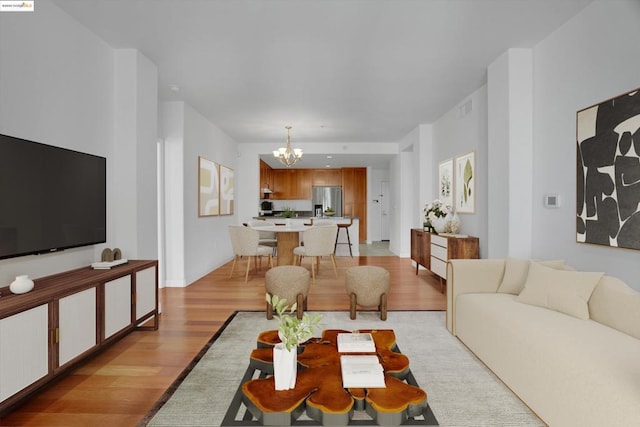 living room featuring light wood-type flooring and a chandelier