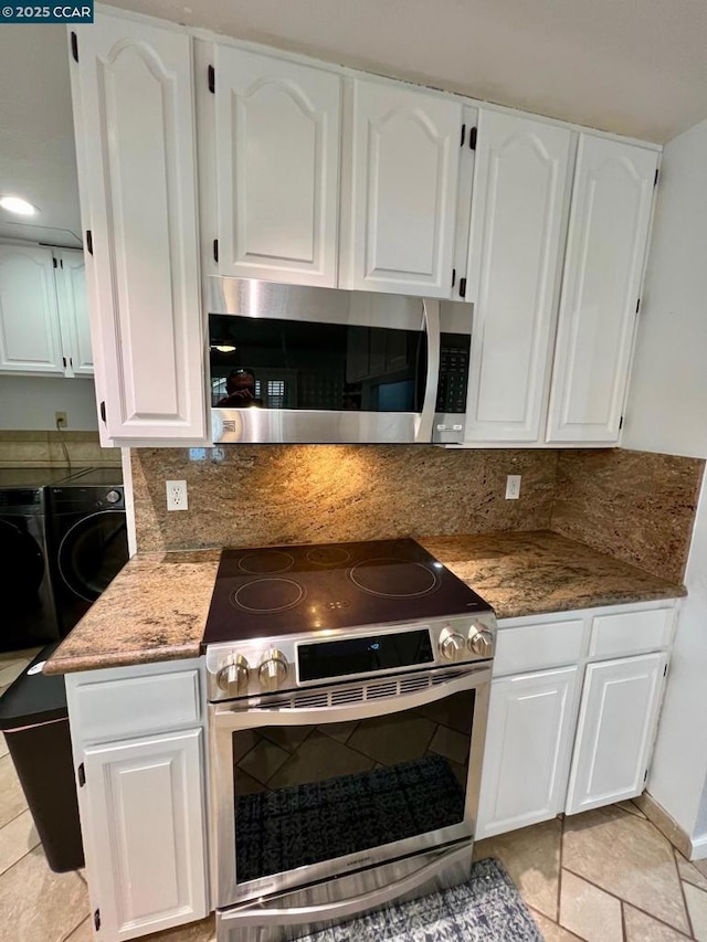 kitchen featuring stainless steel appliances, white cabinetry, washer and clothes dryer, and light tile patterned floors