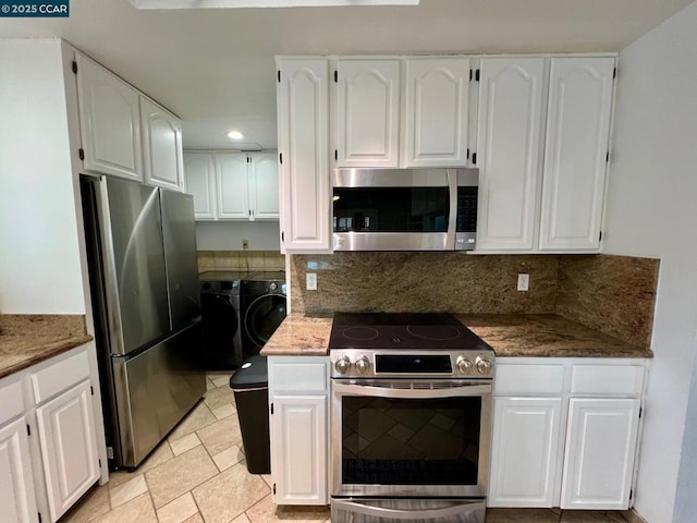 kitchen featuring appliances with stainless steel finishes, tasteful backsplash, white cabinetry, and washer and dryer