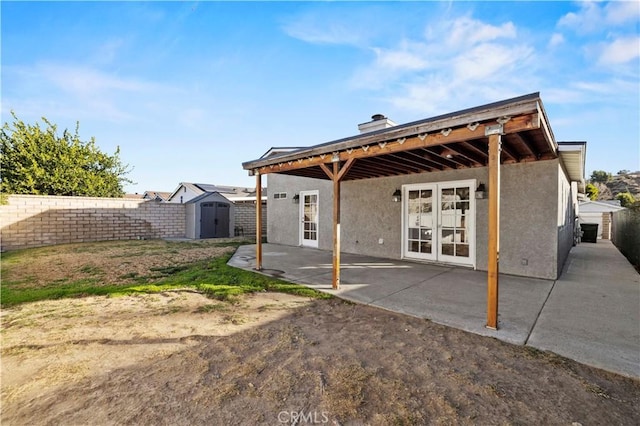 rear view of house featuring a patio and a shed