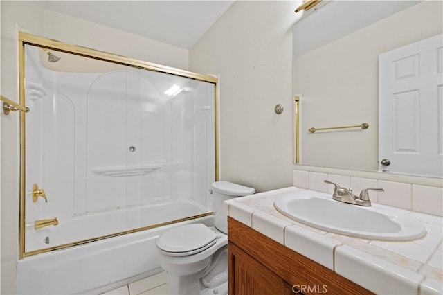 full bathroom with toilet, vanity, bath / shower combo with glass door, and tile patterned flooring