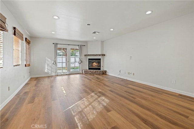 unfurnished living room featuring hardwood / wood-style floors and french doors