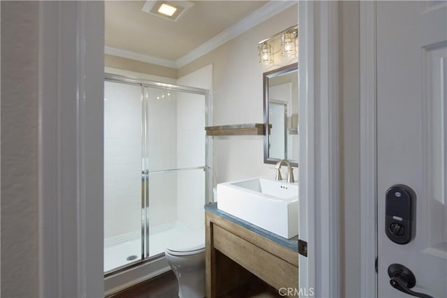 bathroom featuring toilet, crown molding, walk in shower, and vanity