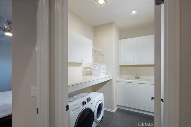 washroom featuring sink, cabinets, and washer and clothes dryer