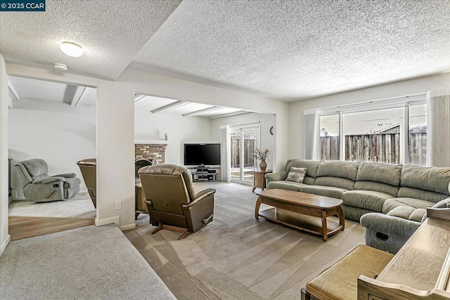 living room featuring a brick fireplace, a textured ceiling, and light carpet