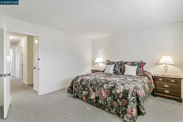 bedroom featuring a textured ceiling and light carpet