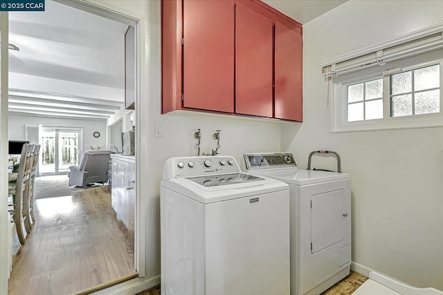 washroom with independent washer and dryer, cabinets, light hardwood / wood-style floors, and plenty of natural light