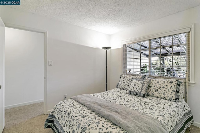 bedroom with a textured ceiling and light carpet