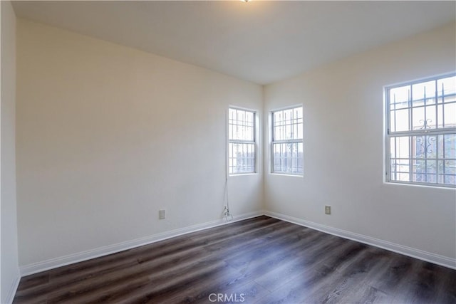 unfurnished room with plenty of natural light and dark hardwood / wood-style floors