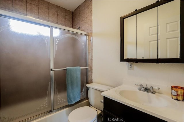 full bathroom featuring enclosed tub / shower combo, vanity, and toilet