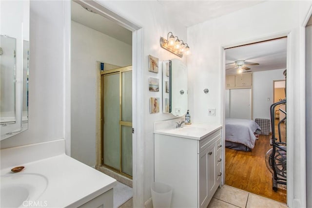 bathroom featuring tile patterned flooring, ceiling fan, walk in shower, and vanity